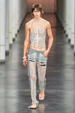A model wearing shredded jeans by Ludovic de Saint Sernin
