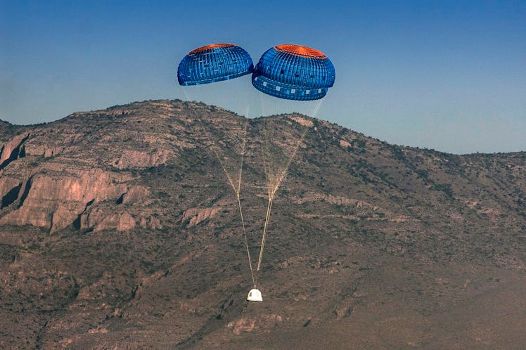 Image of Blue Origin's New Shepard spacecraft landing with parachutes.