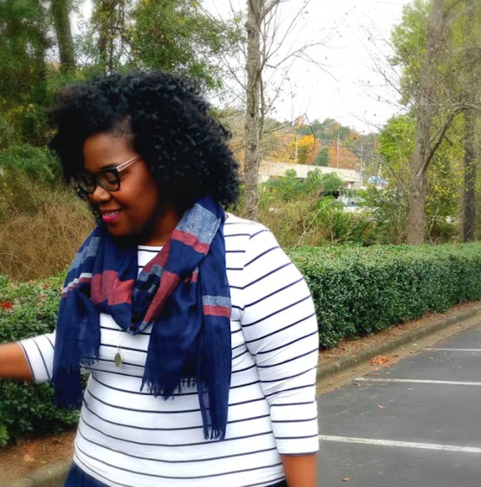 woman with natural hair and sweater around shoulders