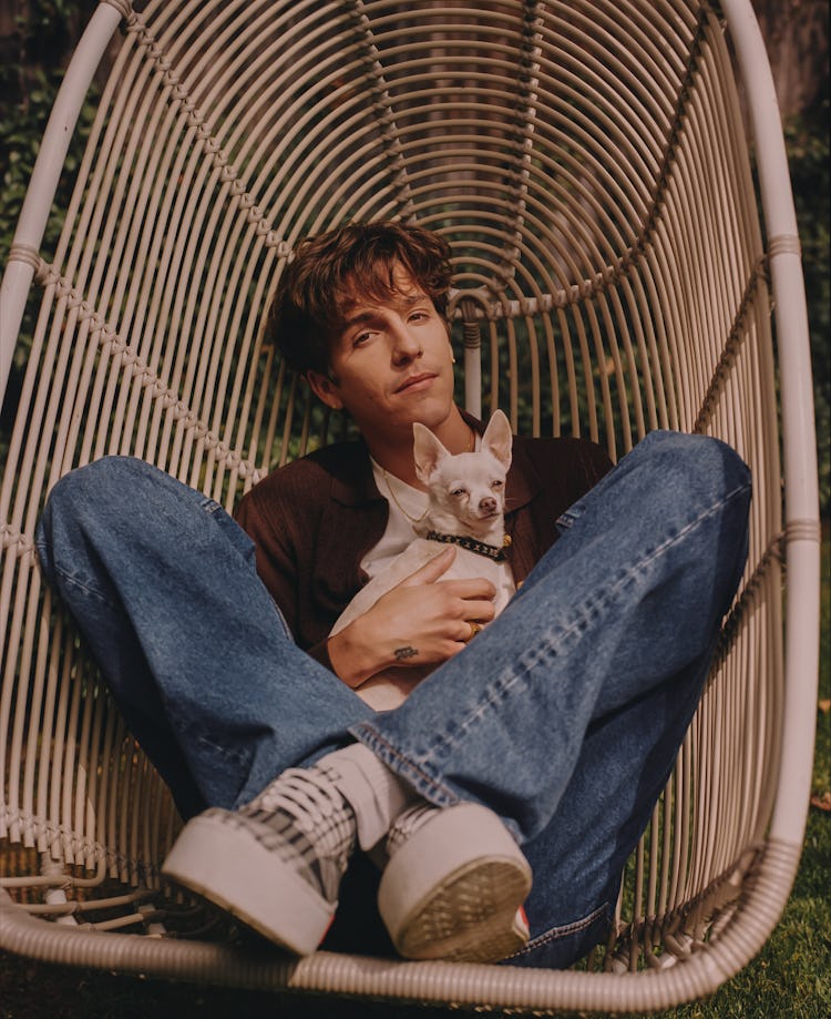 Artist Role Model known for his debut album "RX" laying in a chair swing with a dog