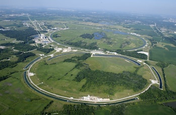 open pasture at fermilab with pipes on top in a loop representing the tevatron