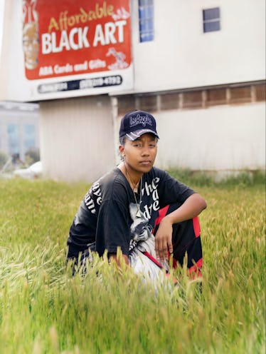 Artist Lauren Halsey sitting in a field of grass