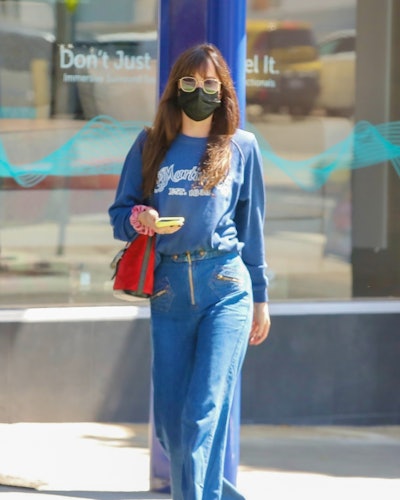 dakota johnson wearing jeans, sweatshirt,  and gucci bucket bag