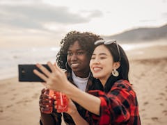 Two friends celebrating because the May 2022 Red Moon total lunar eclipse will affect their zodiac s...