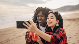 Two friends celebrating because the May 2022 Red Moon total lunar eclipse will affect their zodiac s...