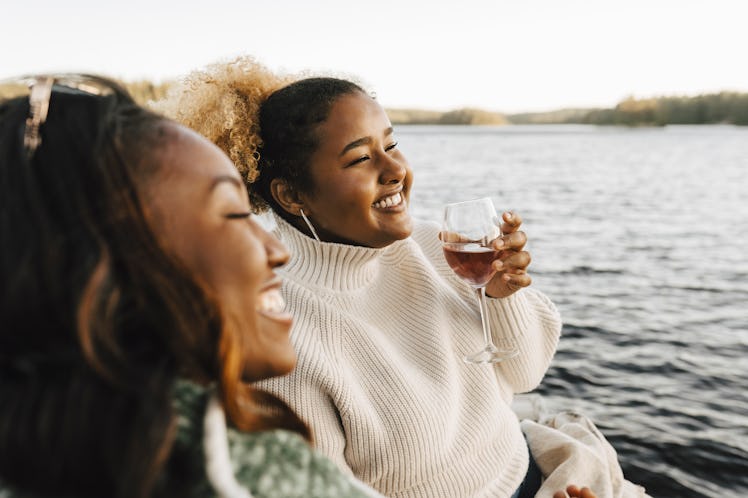 Young women drinking wine during May 2022's Red Moon total lunar eclipse, which will affect their zo...
