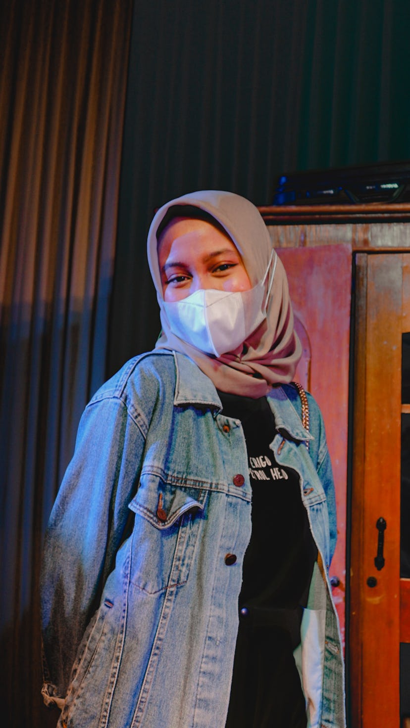 Young woman wearing a mask on Friday the 13th 2022 before reading her zodiac sign's horoscope.