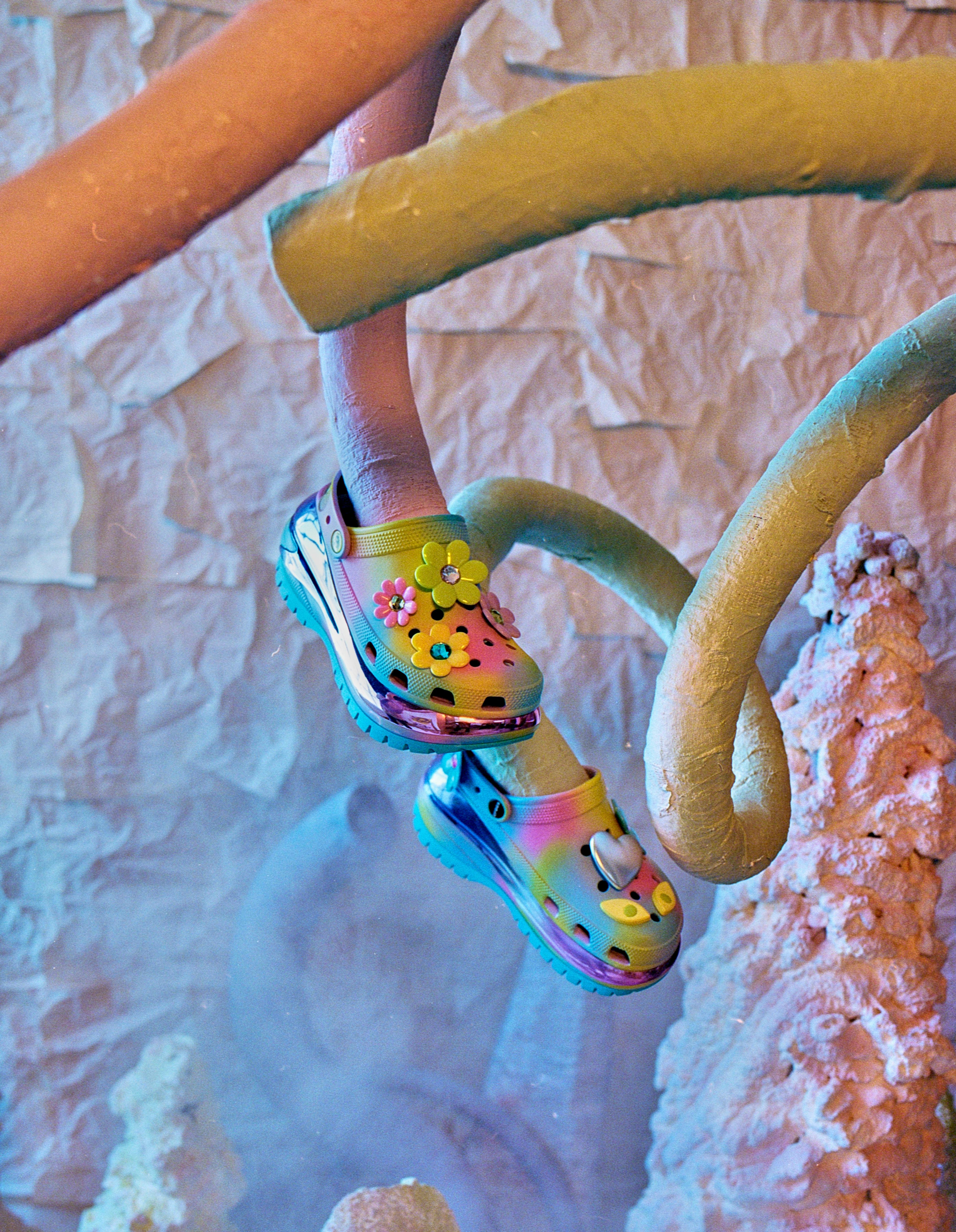 Crocks with some flowers on them on metal poles