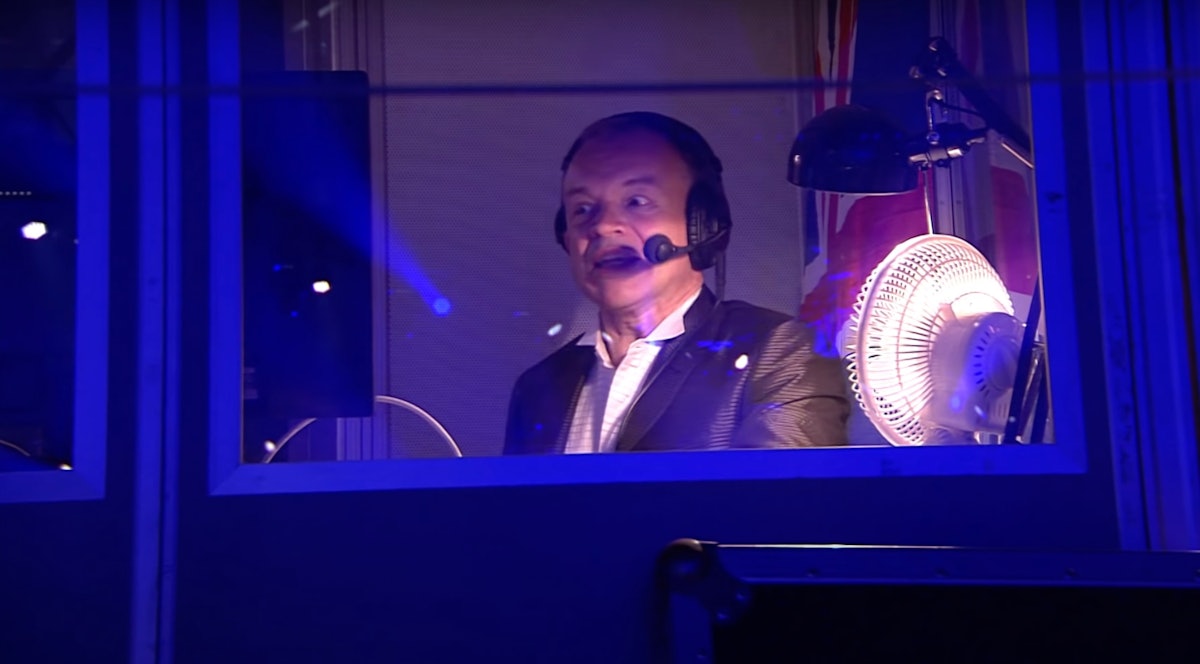 Graham Norton presenting the Eurovision's televised show with headphones and a microphone