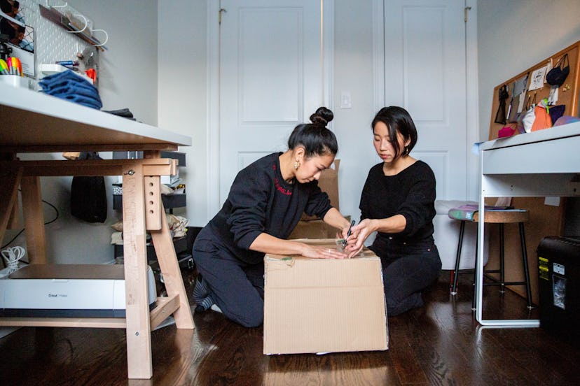 Jess Ng and her business partner Hannah Ryu with boxes of their fashion brand