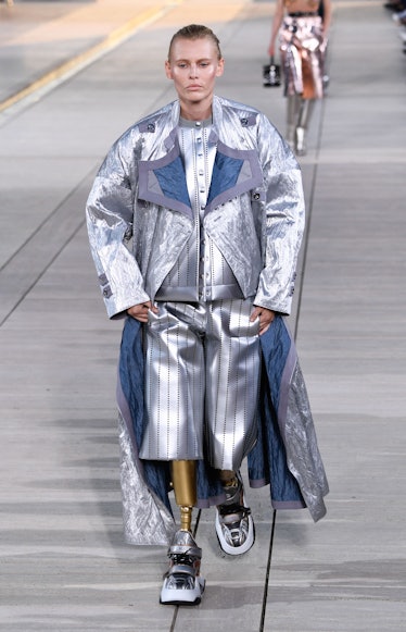 Lauren Wasser walking the Louis Vuitton cruise 2023 show in a silver coat