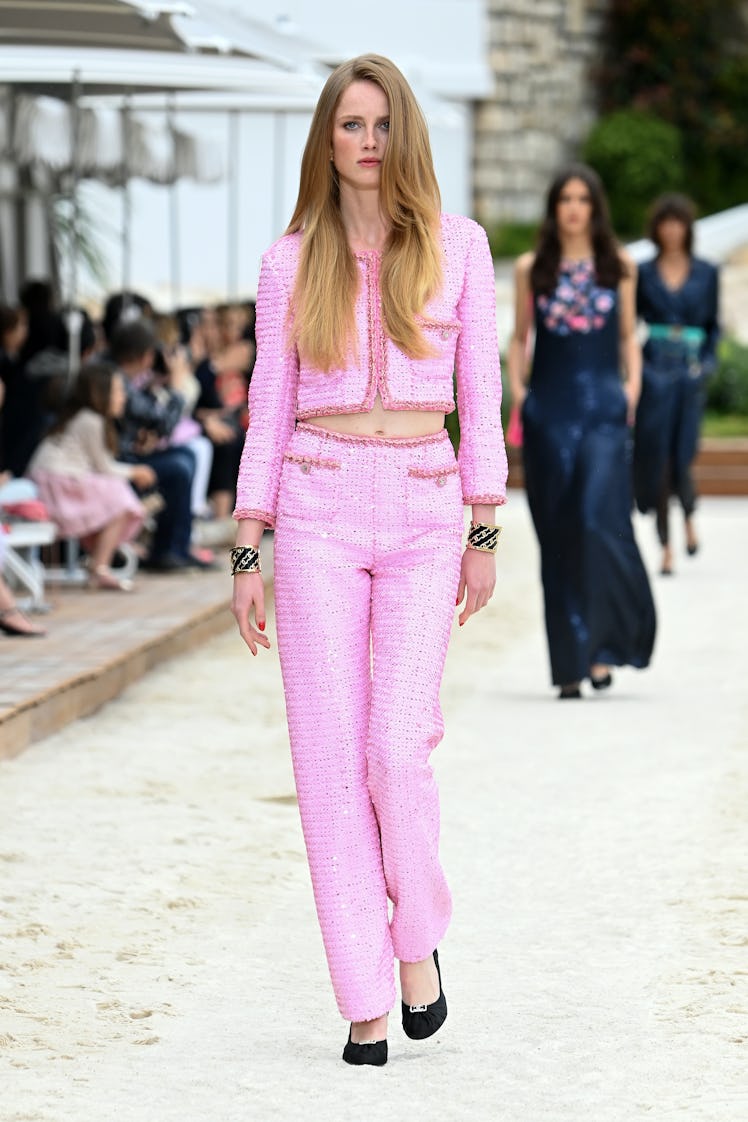 A model walking the runway for the Louis Vuitton's 2023 Cruise Show in a pink blazer and pants combi...
