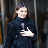 Ms. Kendall Jenner in a black jacket, standing outside. 