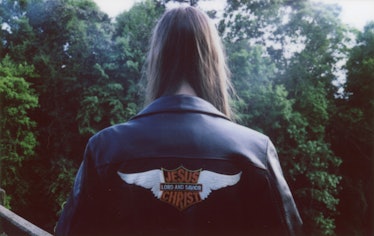 The back of a leather jacket with "Jesus Christ lord and savior" in Harley Davidson style writing 