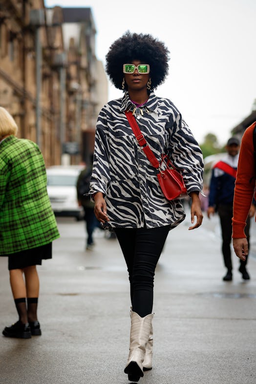  A guest wearing square shape sunglasses, zebra pattern jacket and red cross bag 