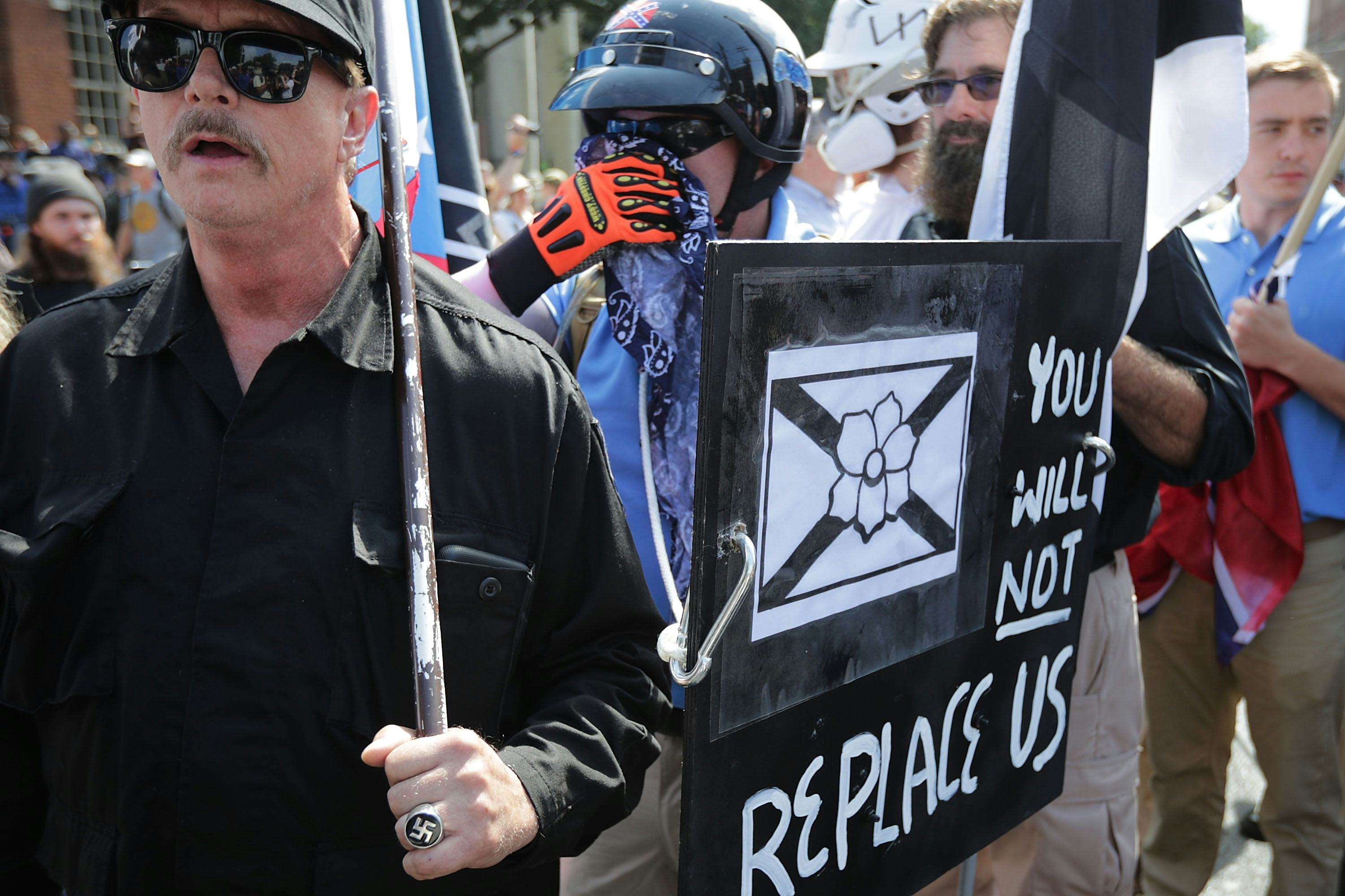 Protesters holding the "You will not replace us" sign