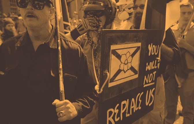 Protesters holding the "You will not replace us" sign