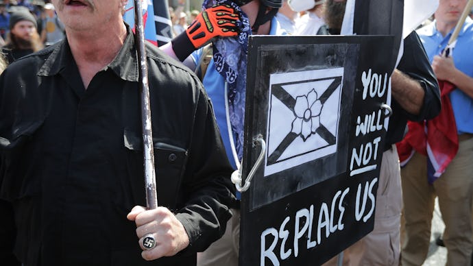 Protesters holding the "You will not replace us" sign