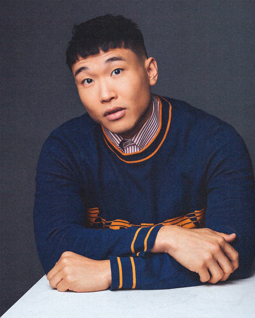Joel Kim Booster wearing a sweater and collared shirt