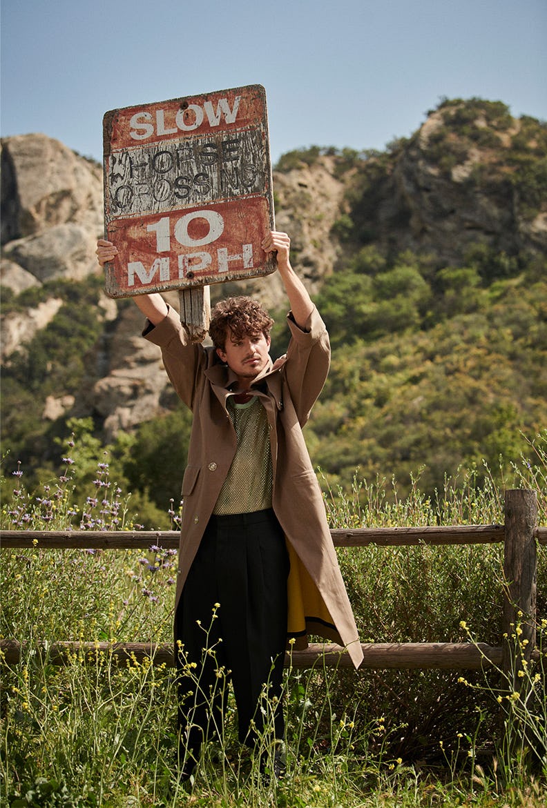 Charlie Puth in a waistcoat, mesh shirt and black pants all by AMI Paris