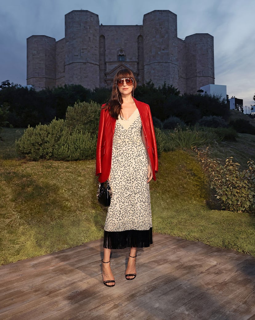 Dakota Johnson in a black and white floral dress with fringe and a red silk blazer