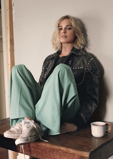 Margot Robbie sitting on a table