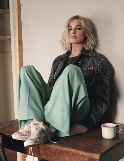 Margot Robbie sitting on a table