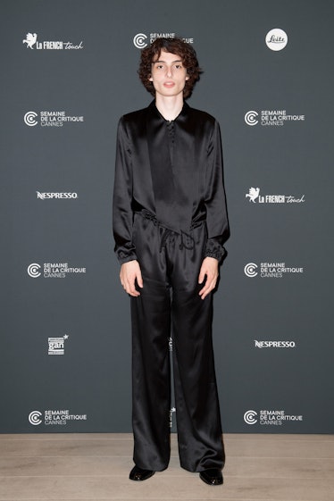 Finn Wolfhard wearing a black satin ensemble at Cannes
