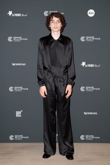 Finn Wolfhard wearing a black satin ensemble at Cannes