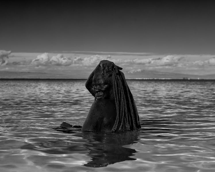 A self-portrait of Zanele Muholi in a body of water