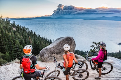 Lake Tahoe, Nevada as the epic family adventure vacation - three mountain bikers looking at the sea ...
