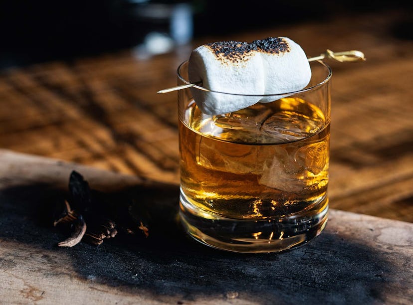 The Colorado Campfire cocktail in a glass with a marshmallow on top of it