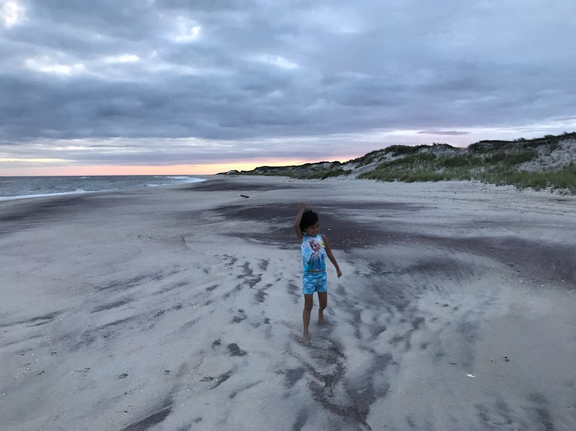 Long Island, New York as the epic family adventure location for camping - a child standing on the se...