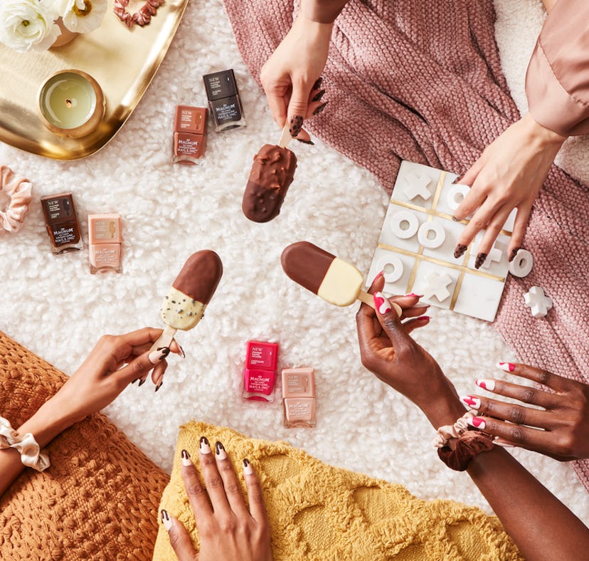 three women wearing the Nails.INC x Magnum Ice Cream nail polish collection eat ice cream.