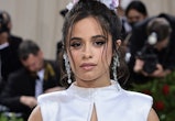 Camila Cabello's Met Gala 2022 hairstyle is the ultimate topknot, complete with a floral accent.