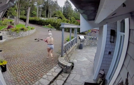 A topless woman wearing gray boxer shorts and nursing an infant chases a bald eagle away from her pe...