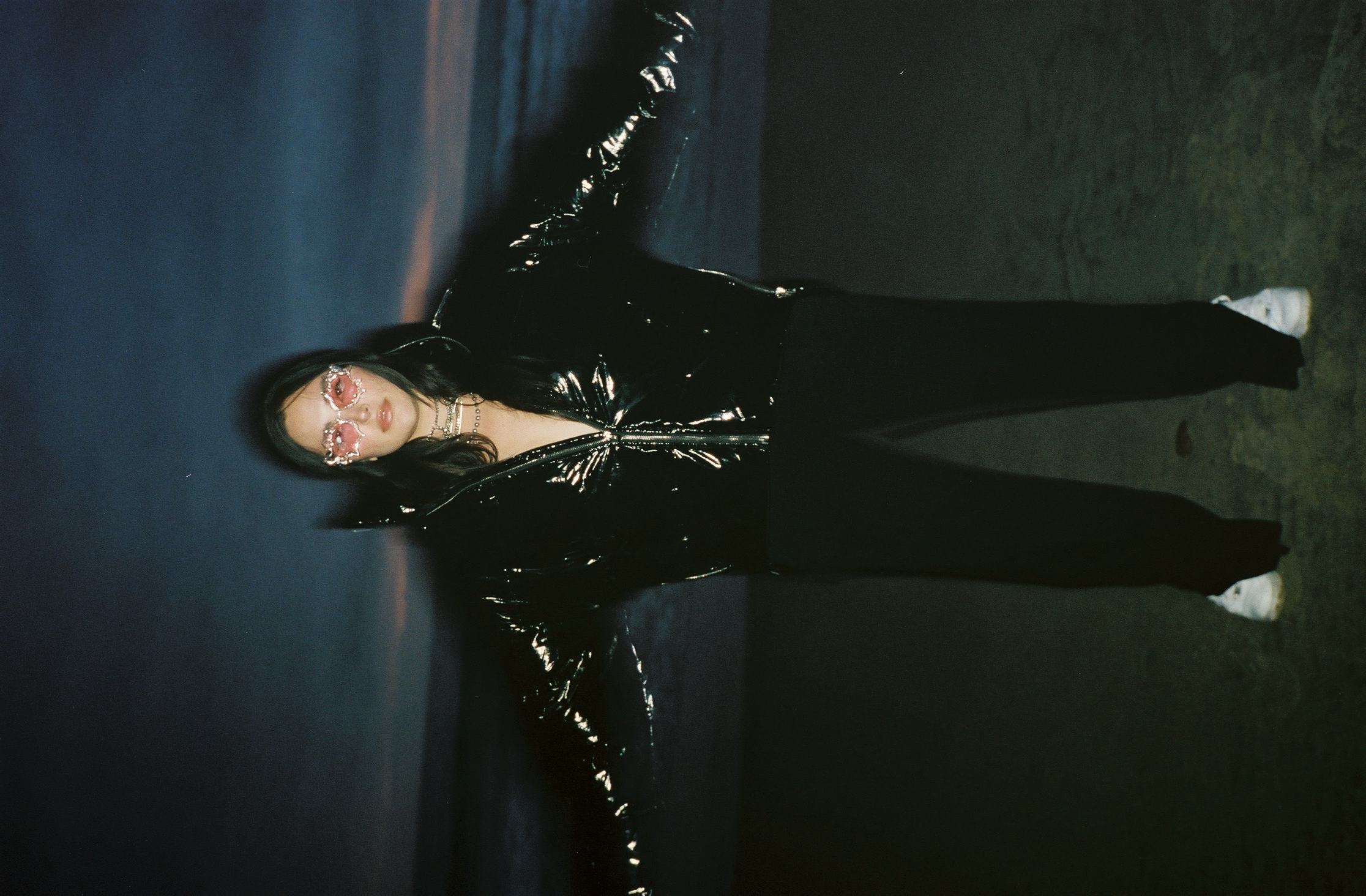 Yumi Nu in a black puffer and pink sunglasses 