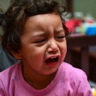 A young child crying, having a temper tantrum.