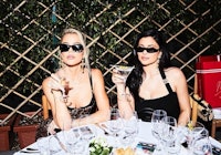 Khloé and Kourtney Kardashian sitting together at a restaurant table