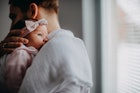 一位患有产后抑郁症的新爸爸抱着刚出生的女儿。
