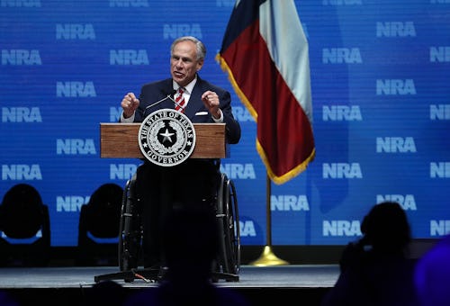 Greg Abbott speaking at the NRA forum with the Texas flag behind him