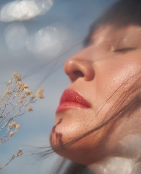 woman facing the sun wearing sunscreen