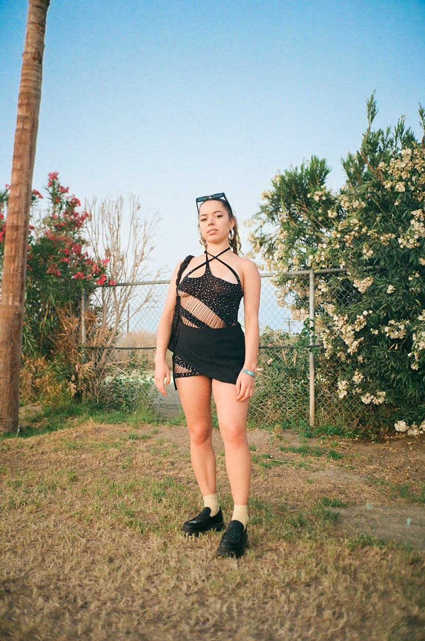 Nilufer Yanya standing outside by a tree