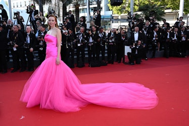 Natasha Bassett wearing a pink gown with a large train at the Cannes Film Festival