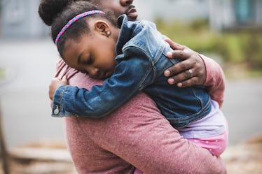 A father holds his scared by school shootings daughter