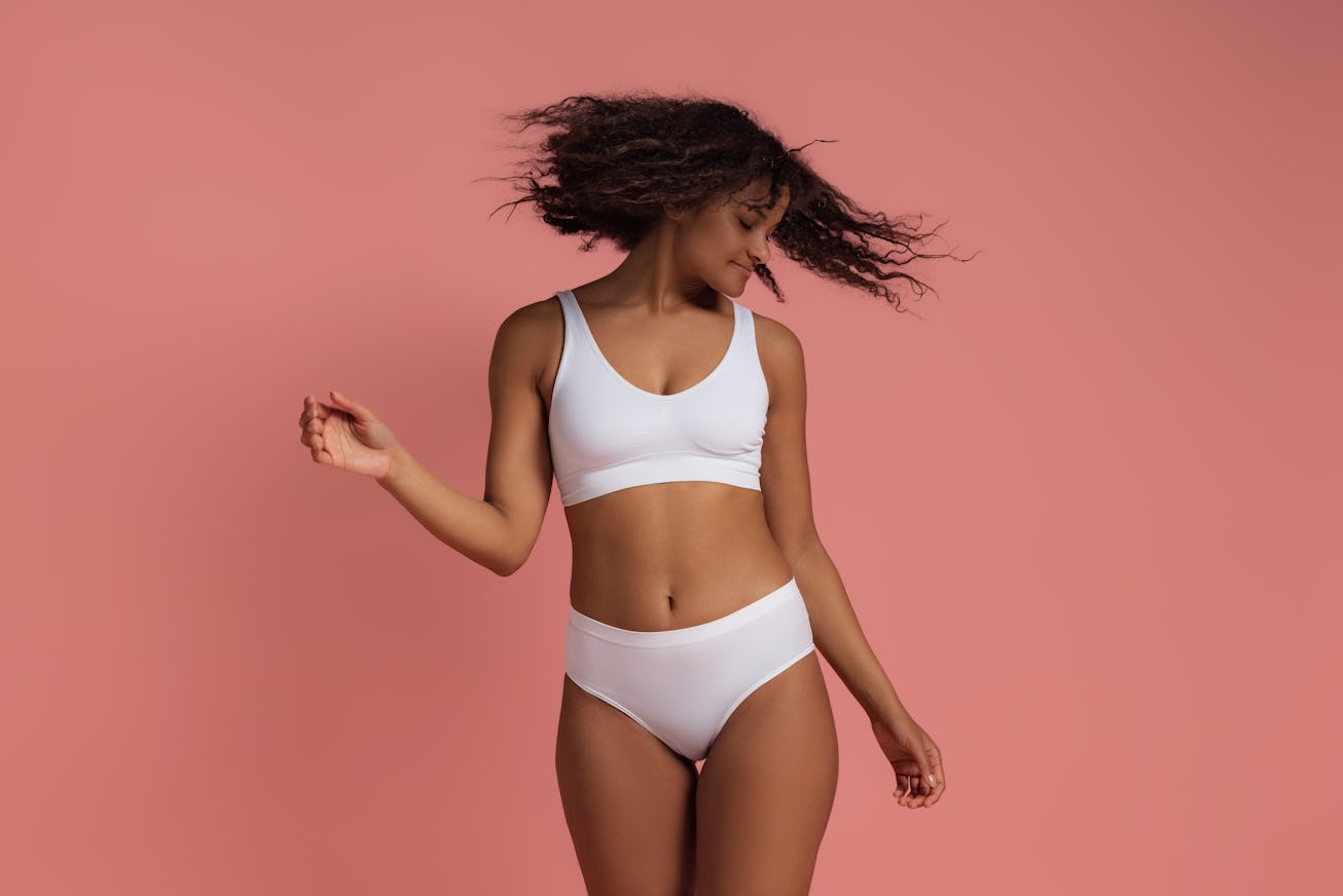Portrait of young happy woman posing in white underwear.