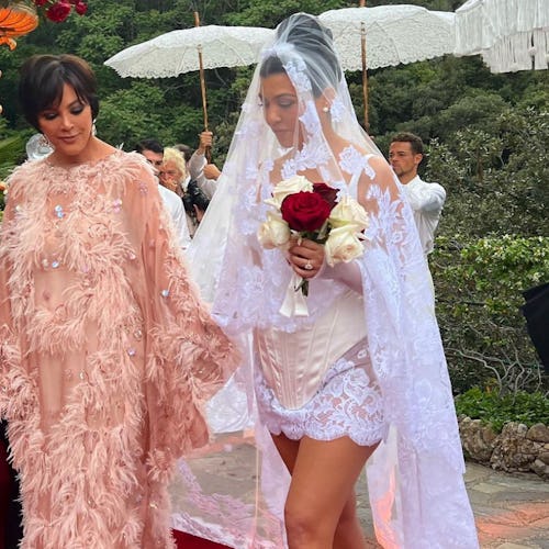 Kourtney Kardashian in a wedding dress walking with her mother Kris Jenner