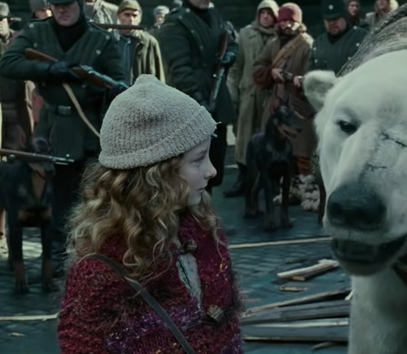 Lyra stands next to her polar bear in The Golden Compass, coming to Netflix in June 2022.