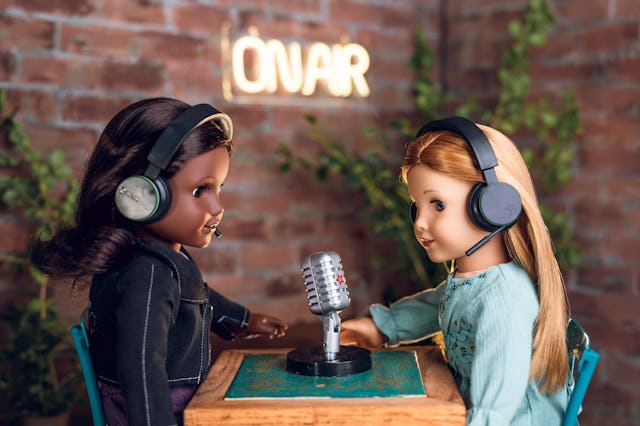 Two dolls are shown hosting a podcast — American Girl is launching a new podcast network.