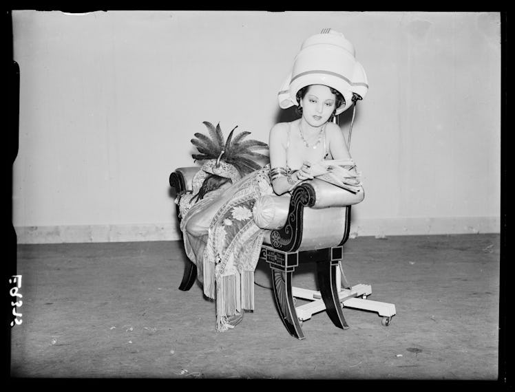A woman under a round blowdryer